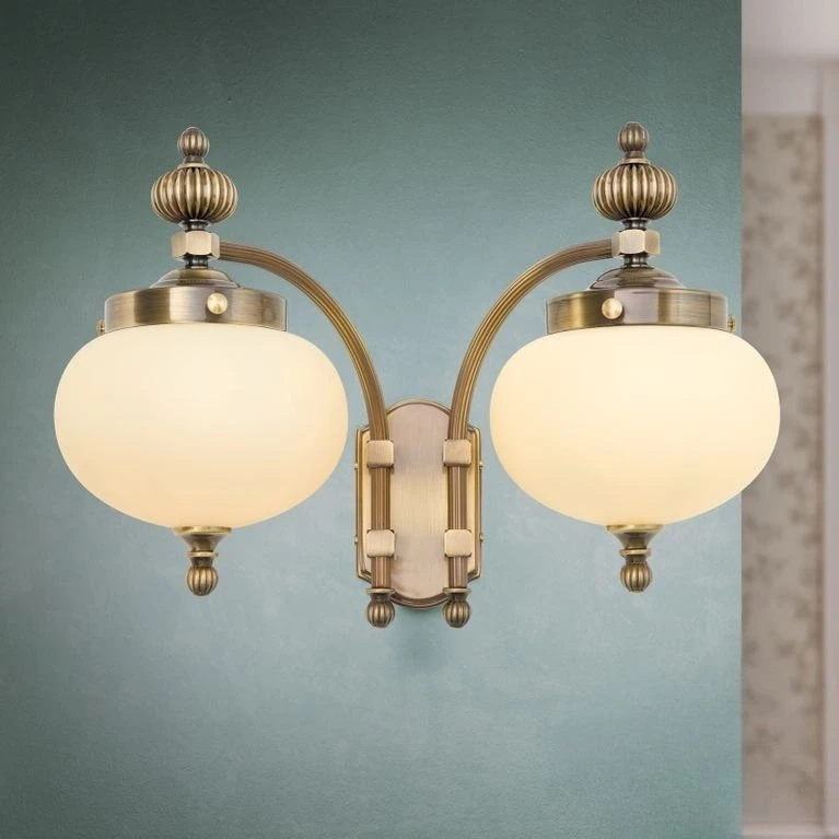 Zidna lampa WIENER NOSTALGIE, 2 izvora svetla, nadole, antik mesing, šampanj staklo
